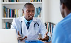 African american doctor has bad news for male patient at hospital